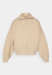 Maglione beige a coste con zip frontale, colletto alto e maniche oversize. Tessuto morbido e orlo corto per una vestibilità rilassata.