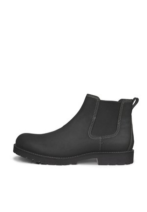 Zwarte Chelsea-boot met elastisch zijpaneel, treklus achteraan, zichtbare stiksels en een platte robuuste zool, getoond in profiel op een witte achtergrond.