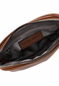 Intérieur d'un portefeuille en cuir marron avec une doublure grise, comportant une fermeture zippée et une petite étiquette en cuir portant les mots "EMILY & NOAH."