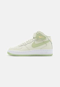 Zapatillas Nike Air Force 1 de media altura en cuero verde claro y crema, con detalles a juego, suela de goma blanca texturizada y correa de Velcro.
