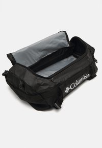 Zwarte sporttas met een grijze binnenkant, ritssluiting, Columbia-logo en webbing handvatten voor het dragen. Kenmerkt zich door duurzaam materiaal en een gestructureerd ontwerp.
