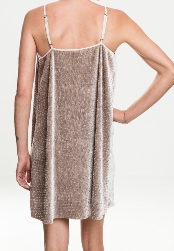 Robe nuisette en velours, beige avec un motif texturé subtil, bretelles ajustables, tombant librement jusqu'au milieu des cuisses, finition en tissu lisse.