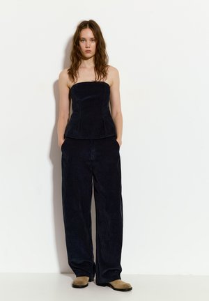 Navy Cordhosen-strapless Top mit strukturiertem Oberteil, kombiniert mit weiten Cordhosen, beide mit einer weichen Textur und lässiger Passform.