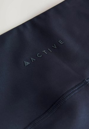 Tumed atleetikakanga tekstureeritud pinnaga, millel on üles tõstetud "ACTIVE" logo. Silmapaistvad õmblused serva ääres.