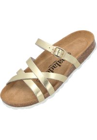 Sandal con cinturino metallico dorato e design incrociato, chiusura con fibbia e soletta in sughero. Texture liscia e suola piatta.
