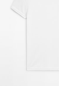 T-shirt blanc uni à manches courtes, vu de face, avec bords de manches repliés et texture de tissu lisse.