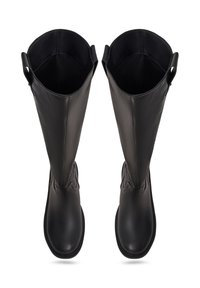 Botas altas de cuero negro con una textura suave, punteras redondeadas y costuras decorativas en el tobillo. Parte superior abierta con bordes redondeados.