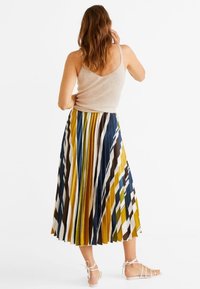 Falda midi plisada con rayas verticales en amarillo, marrón, azul y blanco. Fabricada con un tejido ligero y un diseño fluido.