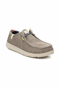 Zapato slip-on de malla beige con un upper texturizado, cordones elásticos y una suela acolchada. El interior cuenta con un forro de dibujos coloridos.