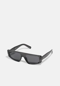 Gafas de sol negras rectangulares hechas de plástico grueso, con lentes oscuros y un diseño minimalista con brazos rectos y un sutil logo.
