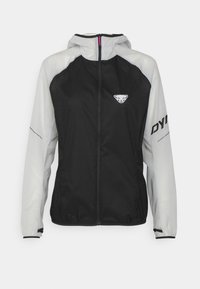 Veste légère noire et grise avec fermeture zippée, capuche, accents réfléchissants et sections perforées pour la ventilation. Logo visible sur la poitrine.