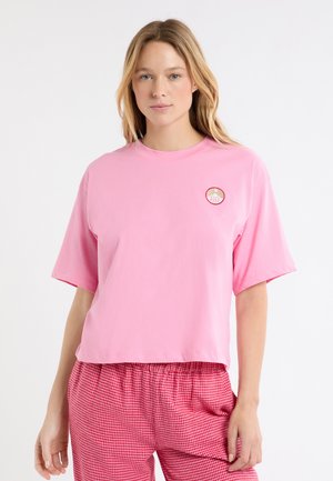 Różowy, bawełniany, oversize t-shirt z okrągłą, haftowaną naszywką z logo po lewej stronie. Krótkie rękawy i okrągły dekolt.