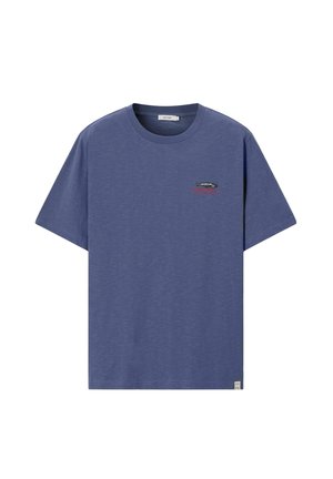 T-shirt bleu à manches courtes et col rond, avec un petit poisson brodé et un texte rouge sur la poitrine gauche, ainsi qu'une étiquette en tissu sur l'ourlet inférieur.