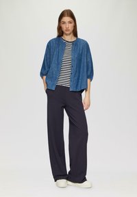 Denim overhemd met knopen, marineblauw gestreept T-shirt eronder, wijde marineblauwe broek en lichtgekleurde sneakers. Eenvoudig, ontspannen pasvorm ontwerp.