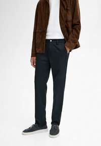 Dark navy trousers made from smooth fabric, featuring a straight leg design, front pockets, and a single button closure.