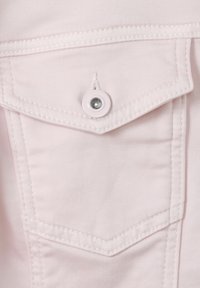 Lichtroze stof met een puntzak en zilveren knoopdetail. Heeft witte stiksels en een gladde textuur, wat wijst op casual wear.