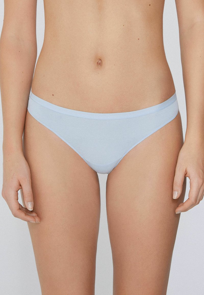 Culotte en coton bleu clair avec une taille fine. Texture lisse, couverture minimale et design sans coutures pour le confort.