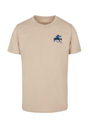 Bež majica od pamuka s kratkim rukavima, okruglim izrezom i plavim grafičkim dizajnom koji prikazuje "PORTUGAL" i dekorativne elemente na prsima.