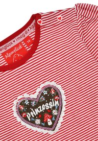 Rot-weiße gestreifte Bluse mit einem herzförmigen gestickten Aufnäher, der bunte Details, gewellte Ränder und herzförmige Knöpfe aufweist.
