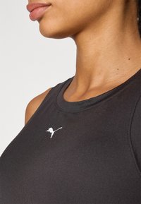 Black athletic tank top featuring a round neckline and a white Puma logo on the chest, made from smooth, stretchy fabric.
