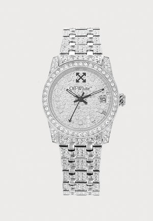 Montre-bracelet de luxe argentée avec ornements en cristal, affichage de la date à 3 heures et marque "Off-White" sur le cadran.