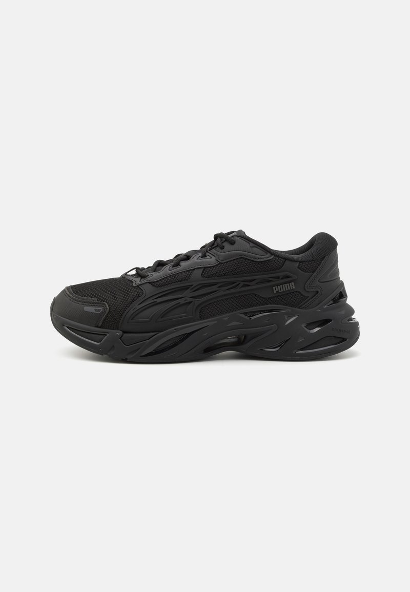 Black athletic shoes with mesh and synthetic material, featuring a textured design, rounded toe, thick sole, and prominent brand logo.
