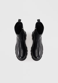 Čierne kožené ankle boots s hladkým povrchom, bočnými zipsami a hrubými gumovými podrážkami. Minimalistický dizajn bez viditeľných vzorov alebo akcentov.