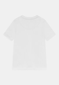 Camiseta blanca de manga corta hecha de tela suave con un cuello redondo, que presenta un diseño simple y una textura lisa. Sin gráficos visibles.