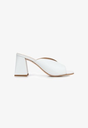 Witte open teen mules met een elegant ontwerp, een soepele leren bovenlaag en een vierkante blokhak met een tan accent aan de basis.