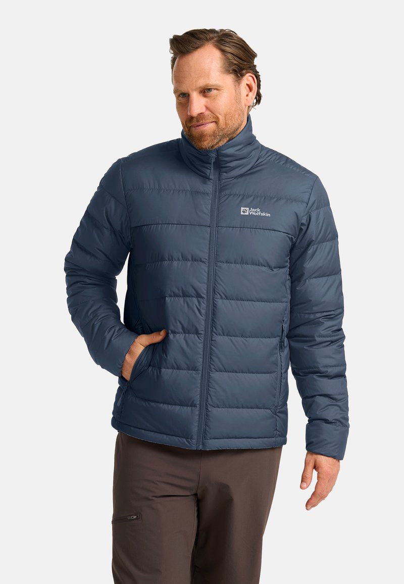 Blaue isolierte Jacke mit Reißverschluss vorne, horizontaler Steppung, hohem Kragen und Logo auf der Brust. Hergestellt aus leichtem, glattem Stoff.