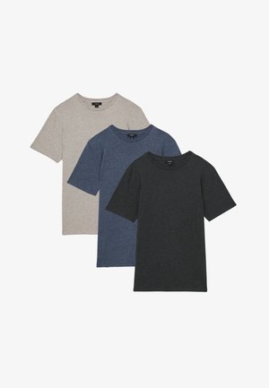 Tres camisetas lisas de cuello redondo y manga corta en beige, azul y gris oscuro, superpuestas unas sobre otras sobre un fondo blanco.