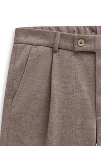 Brown linen trousers with a textured finish, featuring a button closure, side pockets, and front pleats for added detail.