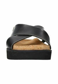 Sandales en cuir noir avec des lanières croisées, semelle intermédiaire en liège et semelle en caoutchouc. Coutures blanches le long des bords des lanières. Design plat.