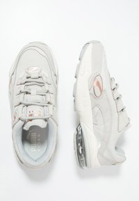 Hellgraue Turnschuhe aus Wildleder und Mesh-Materialien, mit runder Spitze, gepolstertem Kragen, Schnürverschluss und transluzenter Sohle mit Bubble-Design.