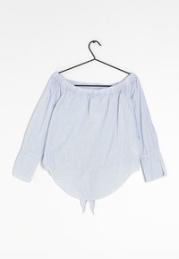 Blouse à rayures bleues et blanches, à épaules nues, avec des manches longues, un col élastique, un ourlet arrondi et un détail de nouage à la taille.
