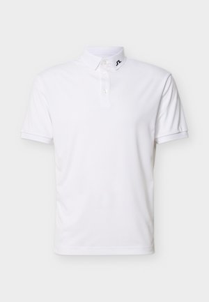 Hvit kortermet polotrøye med tre knapper og en liten svart logo på kragen mot en hvit bakgrunn.