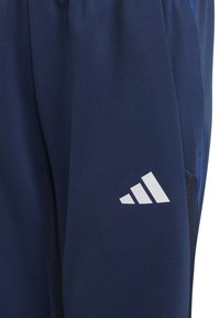 Navy athletic pants made of smooth fabric, featuring a white logo, mesh accents, and elastic waistband for comfort.