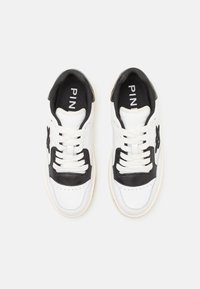 Paire de baskets blanches avec des accents noirs, des lacets blancs et des semelles intérieures noires marquées "PINKO", vues de dessus.