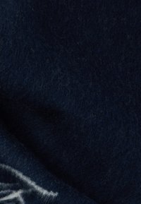 Tumši jūras zilās vilnas audums ar maigu, pūkainu tekstūru, kurai ir nemanāmas dziļuma variācijas un gluda apdare.