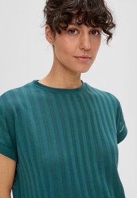 T-shirt w kolorze zielono-niebieskim z poziomymi paskami i okrągłym dekoltem. Krótkie rękawy i miękka tekstura, z szczegółowymi wzorami dzianinowymi.