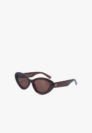 Mørkebrune ovale katteøjne-solbriller med kraftige stel og et diskret guld-dekorativt logo på stangen.