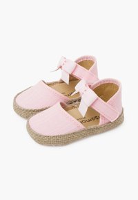 Zapatos de tela rosa con un acabado texturizado, suelas de yute y una cinta decorativa en cada correa. Diseño de punta cerrada y talón abierto.