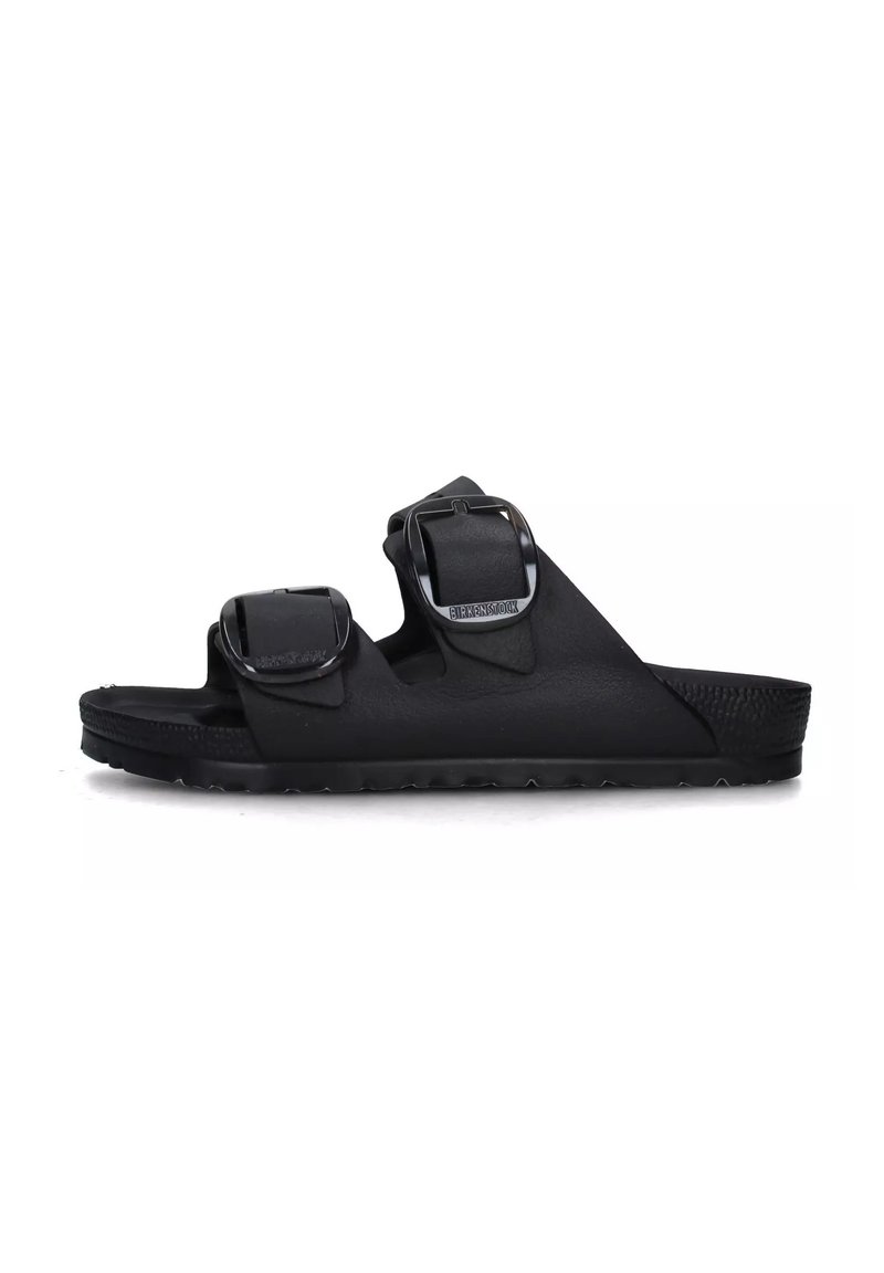 Sandal in nero realizzata in materiale flessibile, dotata di due cinturini regolabili con fibbie in metallo. Sottopiede testurizzato e suola piatta in gomma.