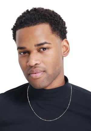 Collana in argento con un mix di maglie texturizzate e lisce, indossata sopra una camicia nera a collo alto, con un tono di pelle chiaro.