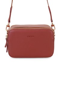 Rote Leder-Umhängetasche mit rechteckiger Form, goldener Reißverschluss und geprägtem Logo auf der Vorderseite. Verfügt über einen schmalen Tragegurt und einen Reißverschlussdetails.