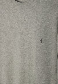 Pull en maille gris clair avec un petit logo brodé représentant une personne jouant au golf sur la poitrine.