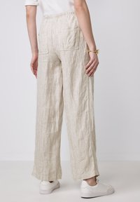 Linnenmix, wijdvallende broek in een beige en crèmekleurig gestreept patroon. Met een elastische tailleband en twee achterzakken.