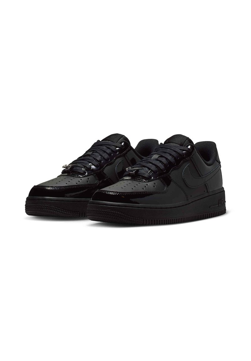 Par de zapatillas Nike Air Force 1 negras brillantes con puntera perforada, cordones negros y suelas texturizadas sobre fondo blanco.