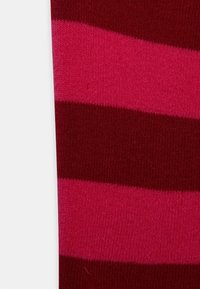 Tecido riscado em vermelho e rosa com uma textura suave; listras largas e estreitas alternadas em vermelho escuro e rosa brilhante.