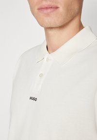 HUGO DANGULA - Bluză polo - open white